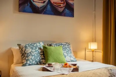 a tray of food sitting on top of a bed at Ollio Quiet City Center Apartments in Belgrade