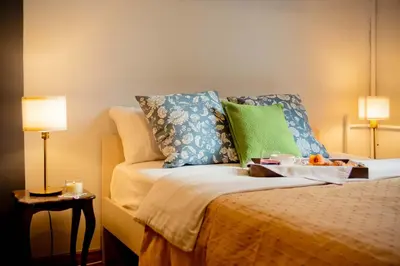 a bed with pillows and a tray of fruit on it at Ollio Quiet City Center Apartments in Belgrade