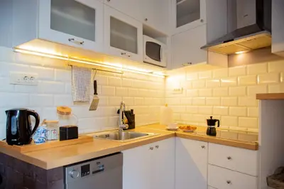 a kitchen with white cabinets and a sink at Ollio Quiet City Center Apartments in Belgrade
