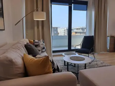 a living room with a couch and a large window at A Blok Exclusive Suite with garage in Belgrade