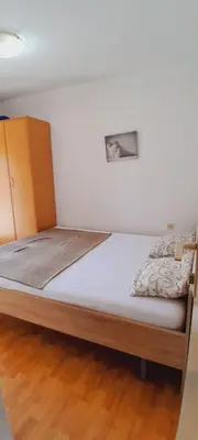a bed in a room with a wooden bed frame at Airport Nikki Apartments in Belgrade