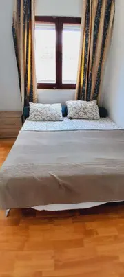 a large bed in a room with a window at Airport Nikki Apartments in Belgrade