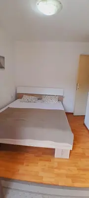 a large bed in a room with a wooden floor at Airport Nikki Apartments in Belgrade
