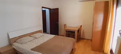 a small bedroom with a bed and a table at Airport Nikki Apartments in Belgrade