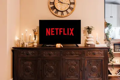 a television on top of a wooden dresser with a clock at Heart Strings with Terrace 290 Mbps Old Town in Belgrade