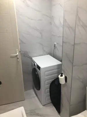 a bathroom with a washing machine and a toilet at Beograd stan na dan in Novi Beograd
