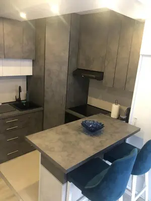 a kitchen with a table and two blue chairs at Beograd stan na dan in Novi Beograd