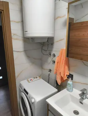 a small bathroom with a washing machine and a sink at IN Zemun Gardos Apartment in Belgrade
