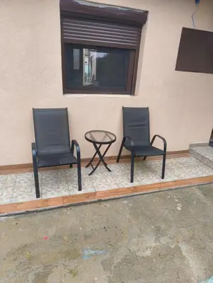 two chairs and a table in front of a building at IN Zemun Gardos Apartment in Belgrade
