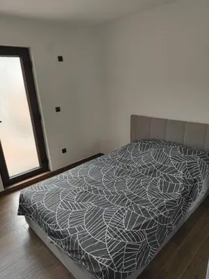 a bedroom with a bed with a black and white comforter at IN Zemun Gardos Apartment in Belgrade