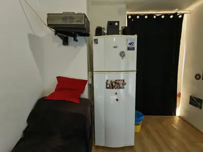 a small room with a refrigerator and a bed at Art studio Banjica in Belgrade