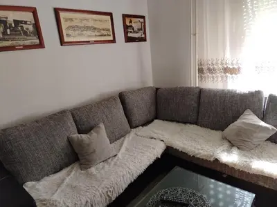a gray couch with pillows on it in a living room at Apartman Selena in Belgrade