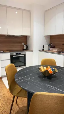 a kitchen with a table with two chairs and a counter at BW Maca - Arcadia in Belgrade