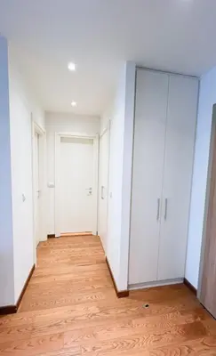 an empty room with white cabinets and a wooden floor at BW Maca - Arcadia in Belgrade
