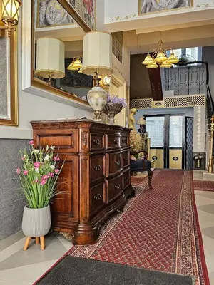 a wooden dresser in a living room with a vase of flowers at Belgrade Luxury Suite 23 in Belgrade