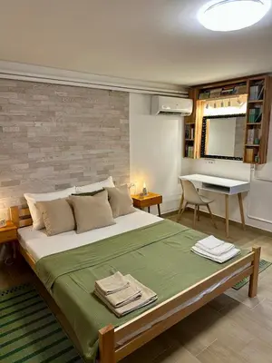 a bedroom with a large bed and a table at M Place in Mirijevo