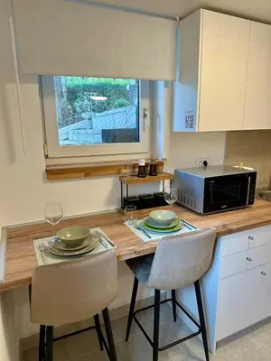 a kitchen with a table with two chairs and a microwave at M Place in Mirijevo