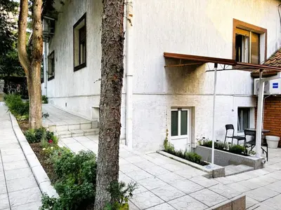 a building with a table and a tree next to it at M Place in Mirijevo