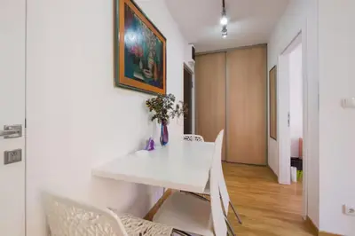 a dining room with a white table and chairs at Sekula's City Center Apartment in Belgrade