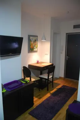 a living room with a table and chairs and a dining room at Sekula's City Center Apartment in Belgrade