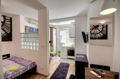 a small room with a bed and a table at Sekula's City Center Apartment in Belgrade
