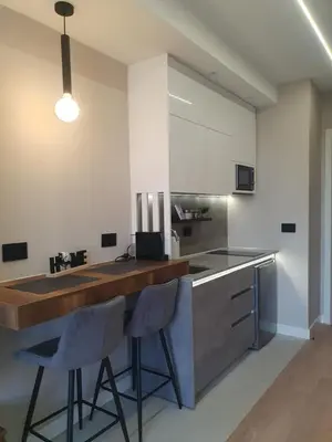 a kitchen with a counter and two stools at a bar at Gallery-mall Studio Belgrade Waterfont in Belgrade