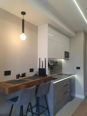 a kitchen with a counter and two stools at Gallery-mall Studio Belgrade Waterfont in Belgrade