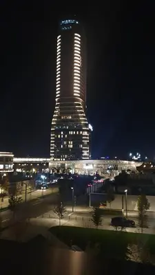 a tall building with lights on it at night at Gallery-mall Studio Belgrade Waterfont in Belgrade