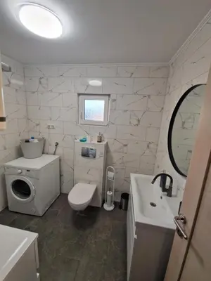 a white bathroom with a sink and a toilet at Elin House in Inđija