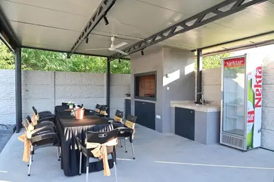 a patio with a table and chairs and a kitchen at Elin House in Inđija