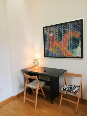a desk with two chairs in a room with a picture on the wall at Luna in Belgrade