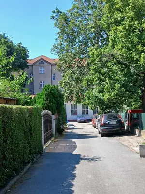 a street with a building and cars parked on the road at Luna in Belgrade