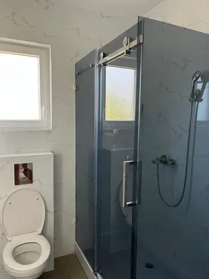 a bathroom with a toilet and a glass shower at Casa Lisović in Lisović
