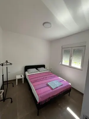 a bedroom with a bed with a pink blanket at Casa Lisović in Lisović