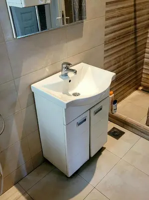 a bathroom with a white sink and a shower at TARAS Hostel in Belgrade