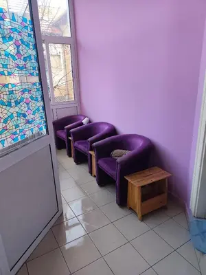 a waiting room with purple chairs and a table at TARAS Hostel in Belgrade