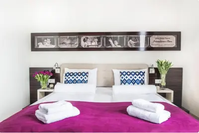 a bedroom with a large bed with two white towels at Theater Hotel Belgrade in Belgrade