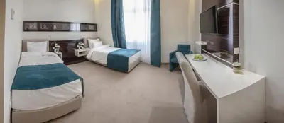 a hotel room with a bedroom with a bed and a desk at Theater Hotel Belgrade in Belgrade