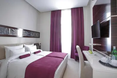 a hotel room with a large bed and a desk at Theater Hotel Belgrade in Belgrade