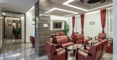 a waiting room with chairs and tables and a tv at Theater Hotel Belgrade in Belgrade