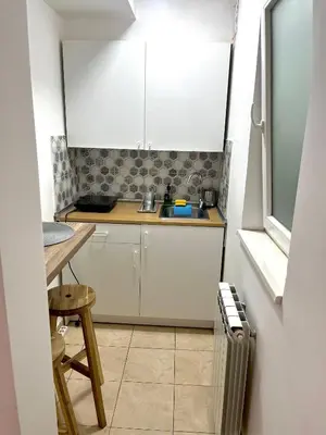 a small kitchen with white cabinets and a sink at A&D apartment in Belgrade