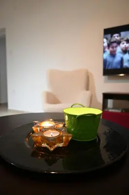 a green bowl and a candle on a table at Lux Star Apartment in Belgrade