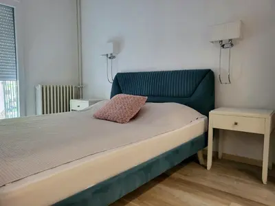a bed with a blue headboard in a room at Lux Star Apartment in Belgrade