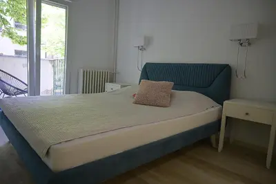 a bed with a blue headboard in a bedroom at Lux Star Apartment in Belgrade