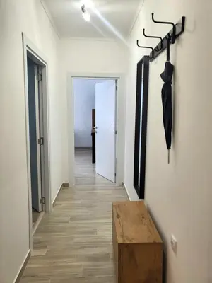 a hallway with a table and an umbrella on a wall at Lux Star Apartment in Belgrade