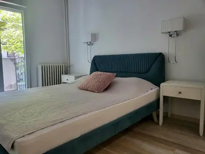 a bedroom with a bed with a blue headboard at Lux Star Apartment in Belgrade