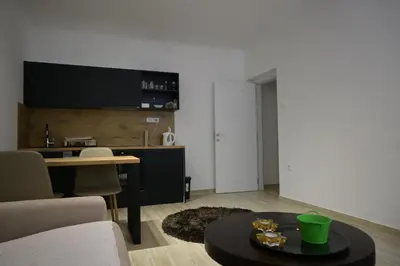 a living room with a table and a kitchen at Lux Star Apartment in Belgrade