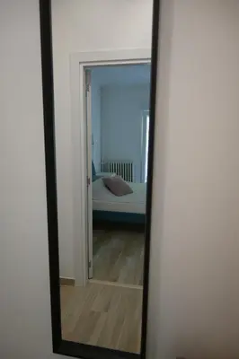a mirror reflecting a bedroom with a bed in a room at Lux Star Apartment in Belgrade