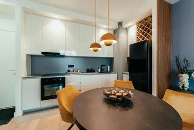 a kitchen with a table and chairs and a kitchen with white cabinets at BW City Elegance Collection in Belgrade