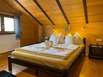 a bedroom with a large bed with a bow on it at Kosmajski vajati Petra in Nemenikuće